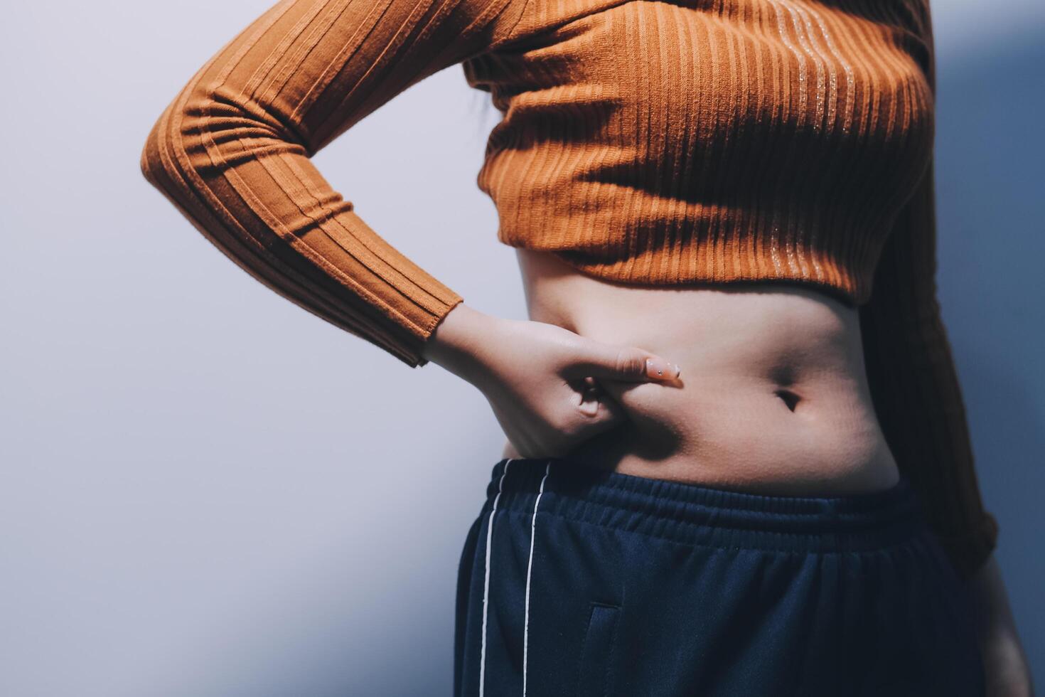 A woman with her stomach showing off her stomach photo