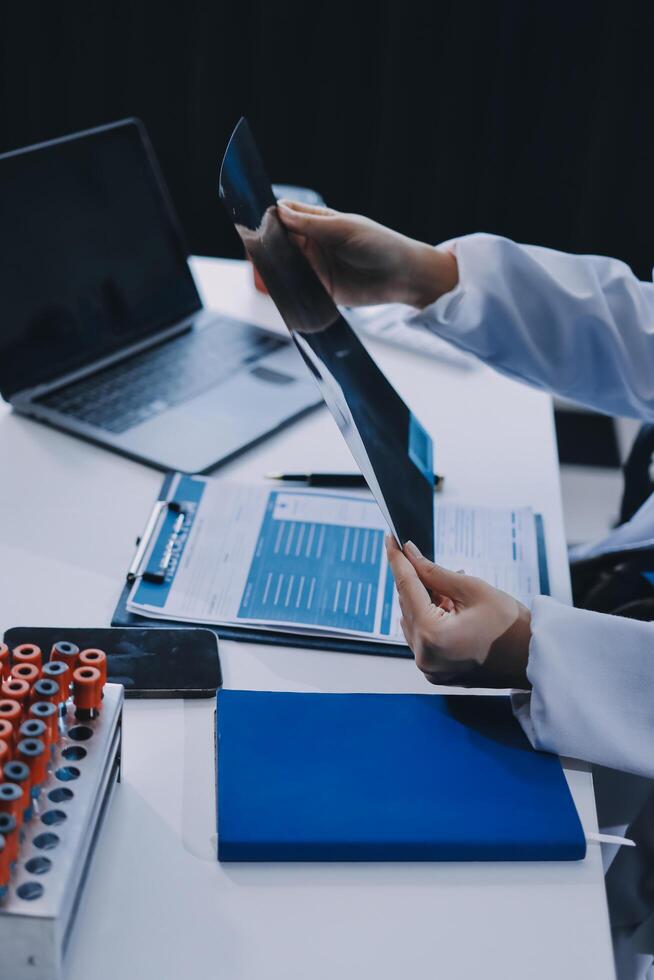 A doctor is working on a laptop and a tablet photo