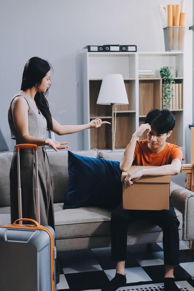 A man and woman are sitting on a couch with a suitcase photo
