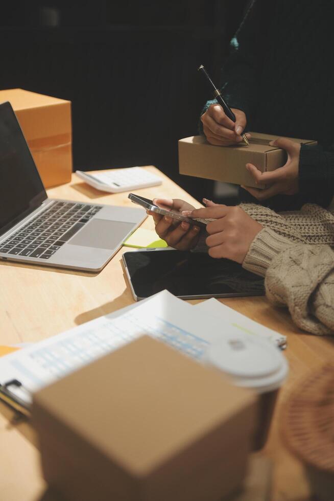 A person working on a laptop and holding a pen photo