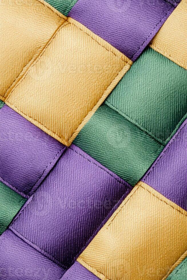Intricate texture of a handwoven quilt showcasing geometric patterns in purple, green, and yellow fabrics photo