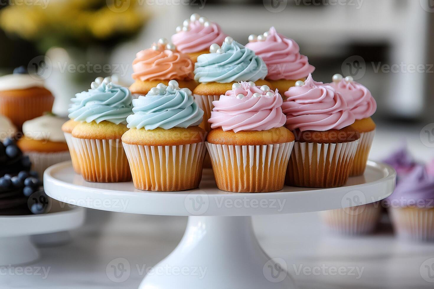 Colorful cupcakes with frosting and pearls sitting on white cake stand photo