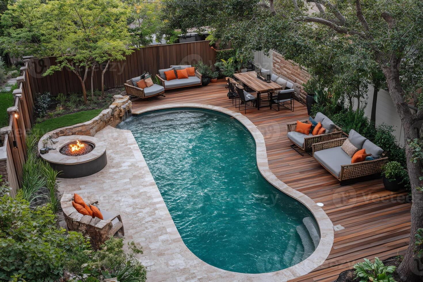 Luxurious backyard featuring a curved swimming pool, fire pit, and outdoor furniture photo