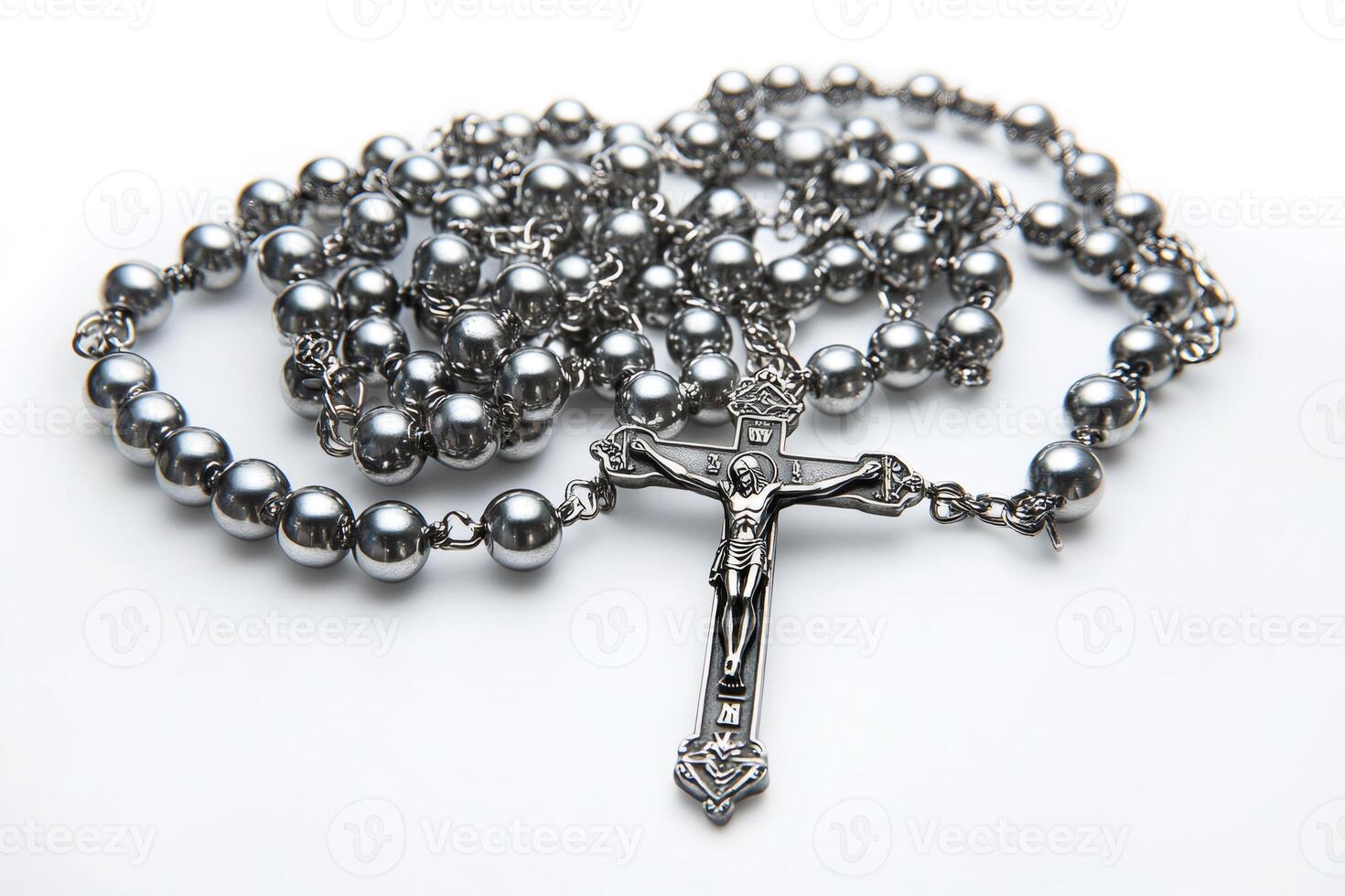 Silver rosary beads with crucifix resting on white background photo