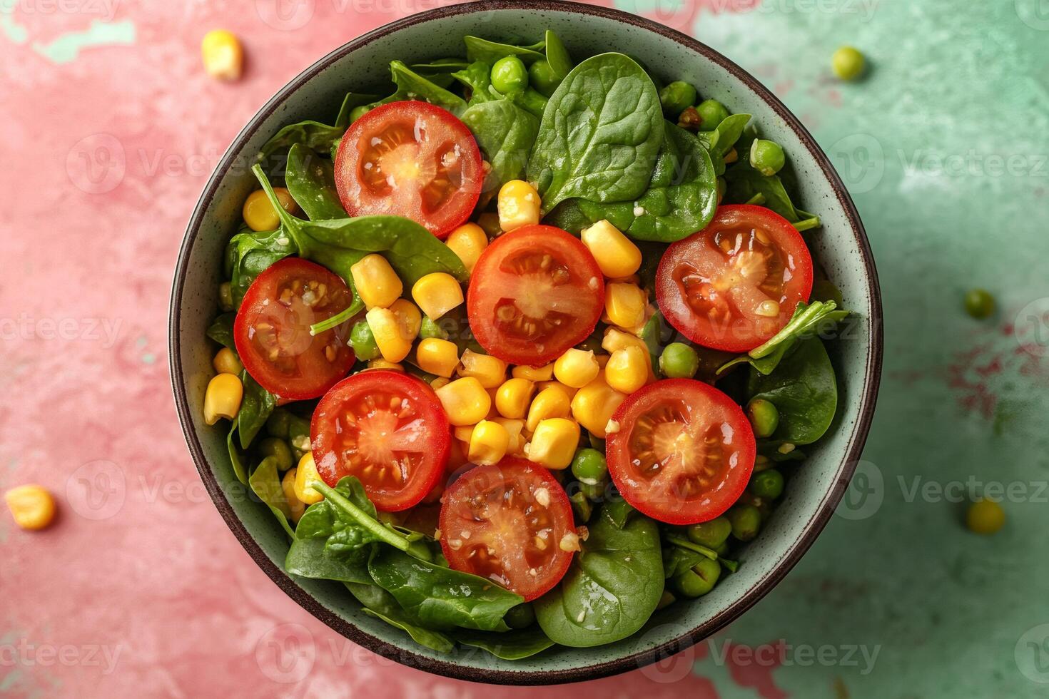 Healthy vegan salad with spinach, tomatoes, corn and peas resting in a bowl photo