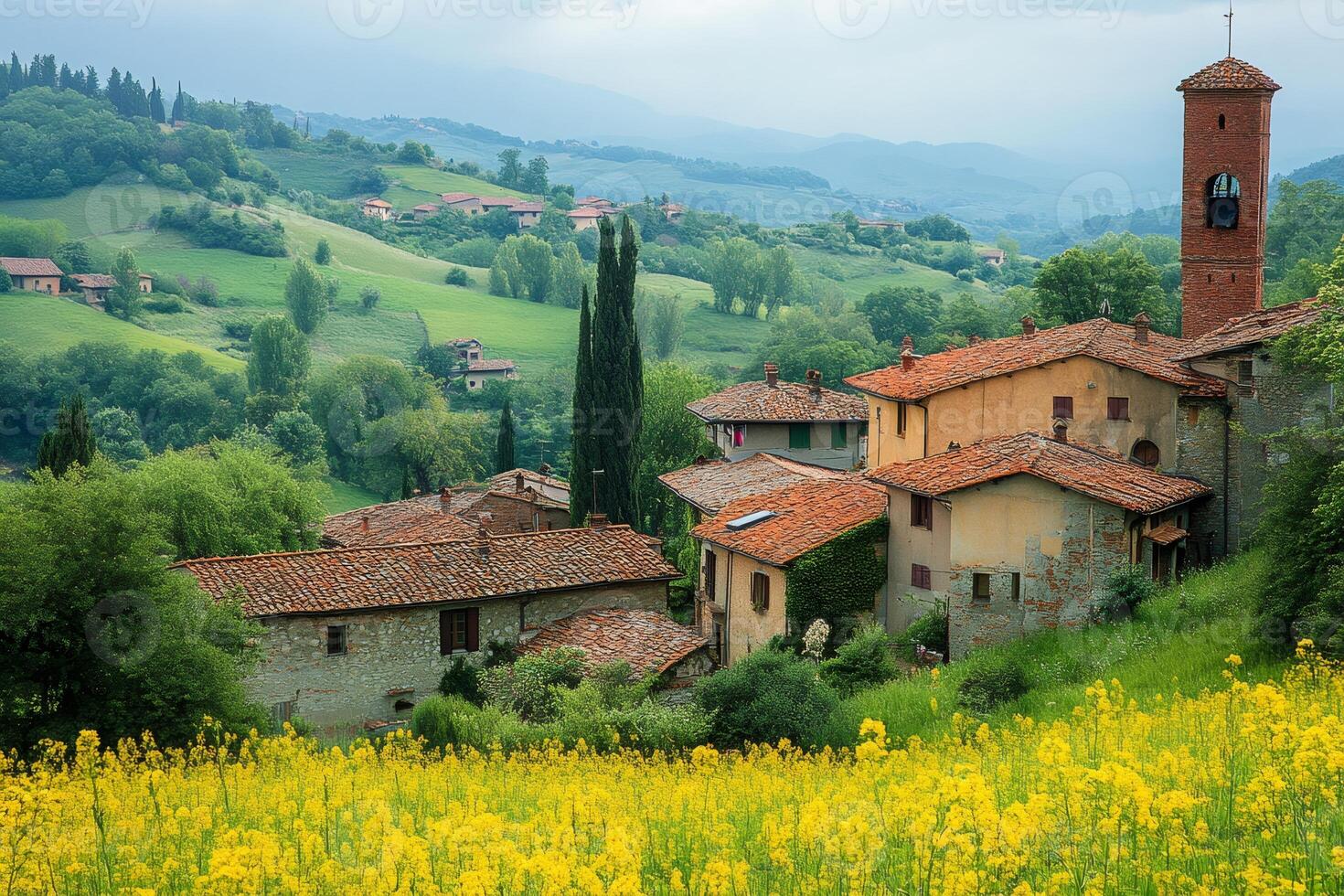 Picturesque tuscany village surrounded by blooming yellow rapeseed flowers photo