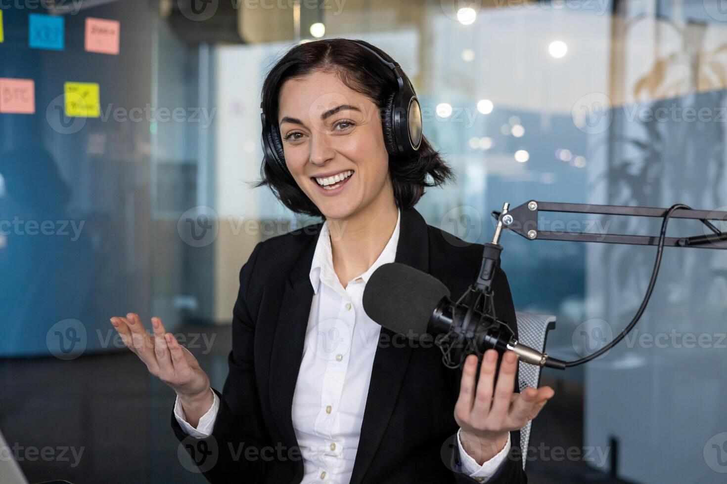 Confident woman in business setting hosting podcast. Smiling expression reflects professional and engaging communication. Office ambience suggests corporate environment. photo