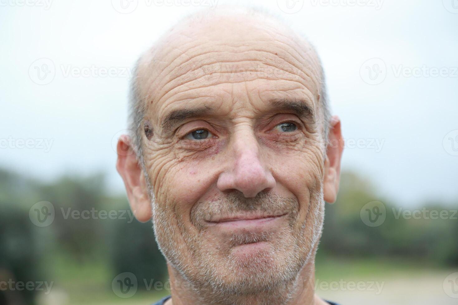 Bald Senior Man Smiles Saying Yes With His Face Outdoors In The Park photo