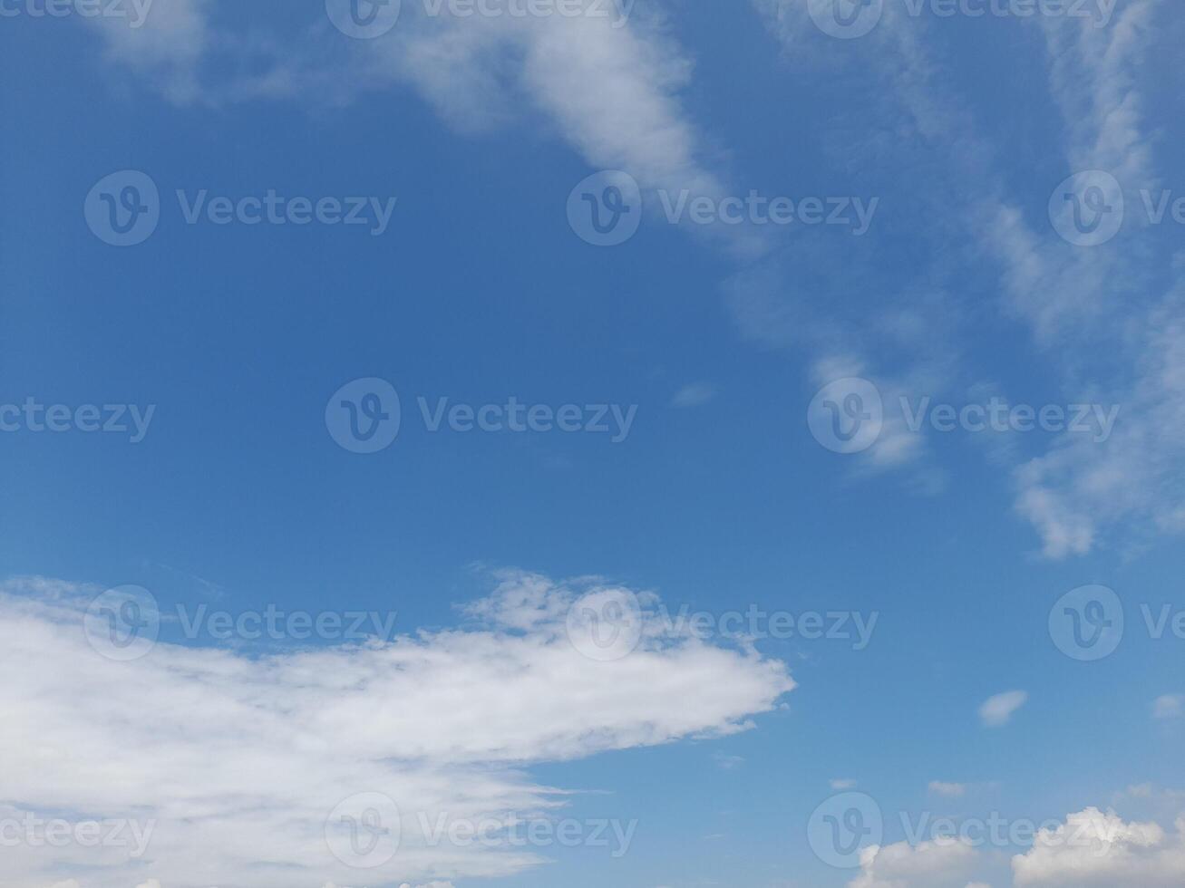 A serene blue sky with delicate clouds drifting lazily across the sky. photo