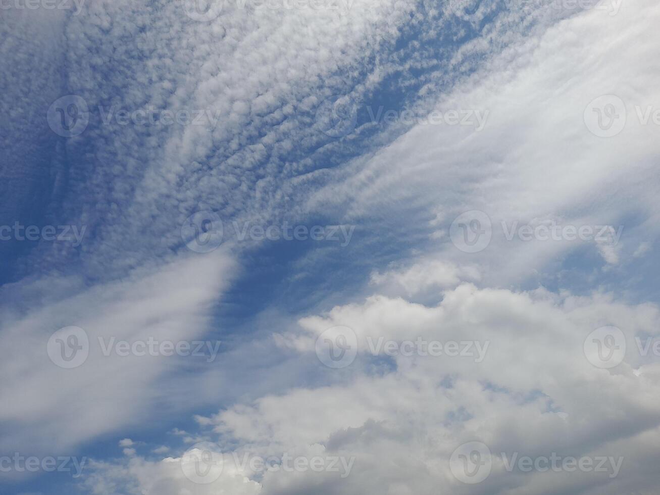 A breathtaking blue sky with a few fluffy clouds scattered here and there. photo
