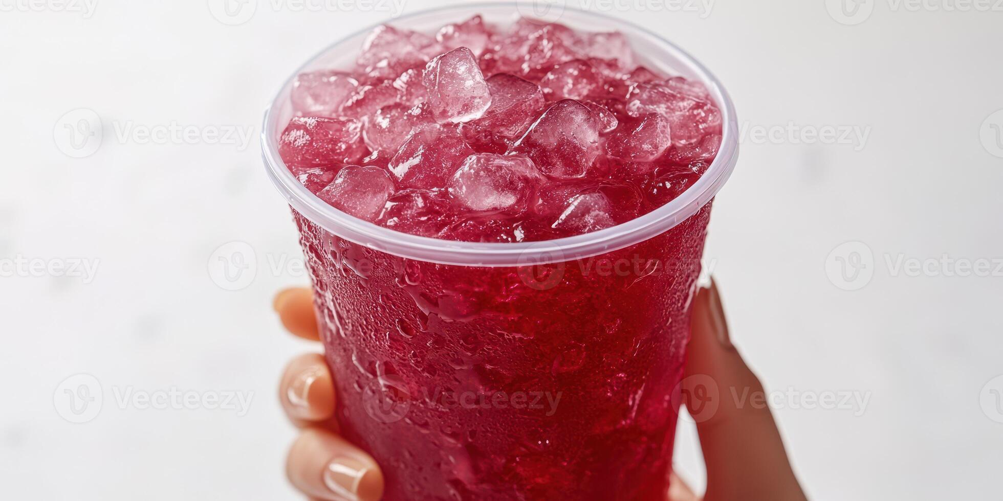 Refreshing beverage served in a clear cup filled with ice and vibrant red liquid during a summer gathering photo