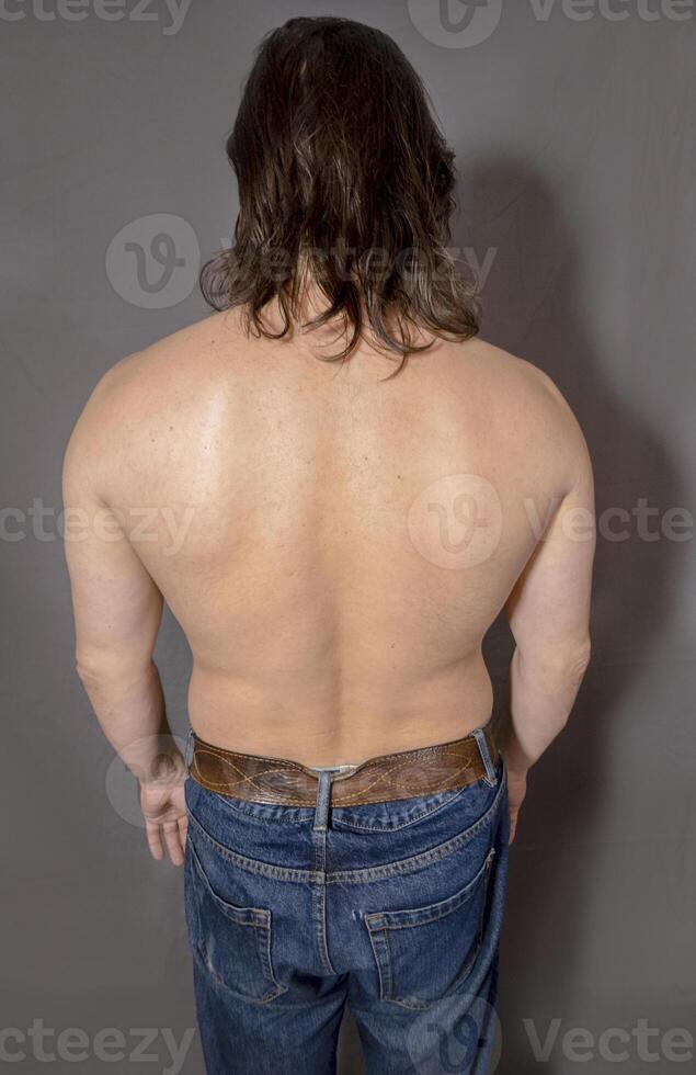 Muscular man back on a grey background. photo