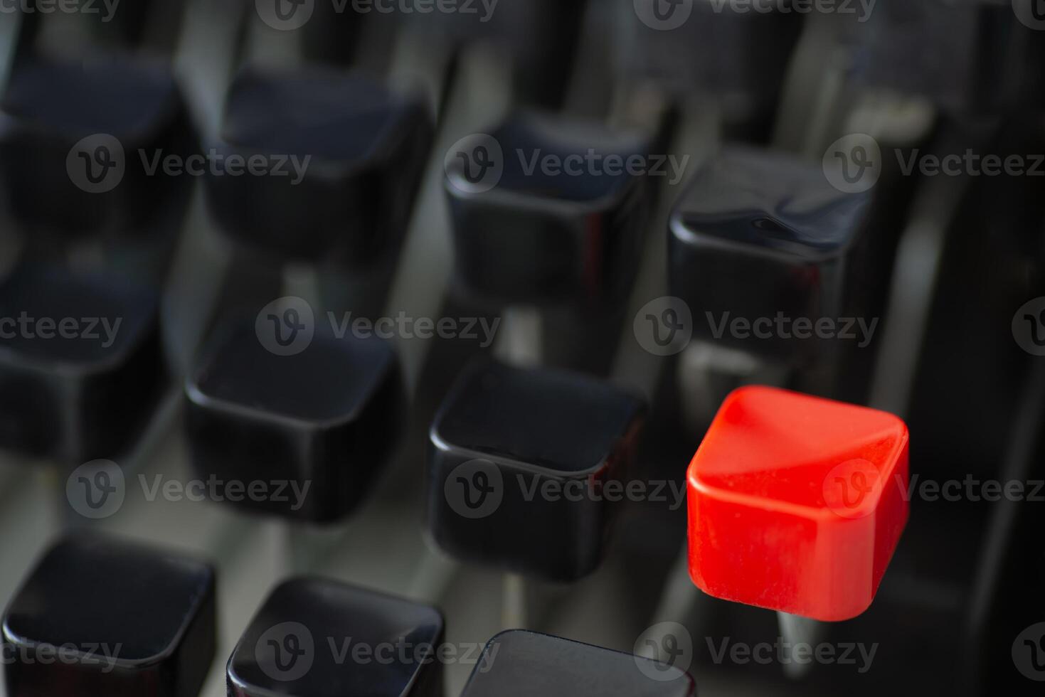 A red typing key stands out among black keys on a retro typewriter creating a striking visual contrast photo