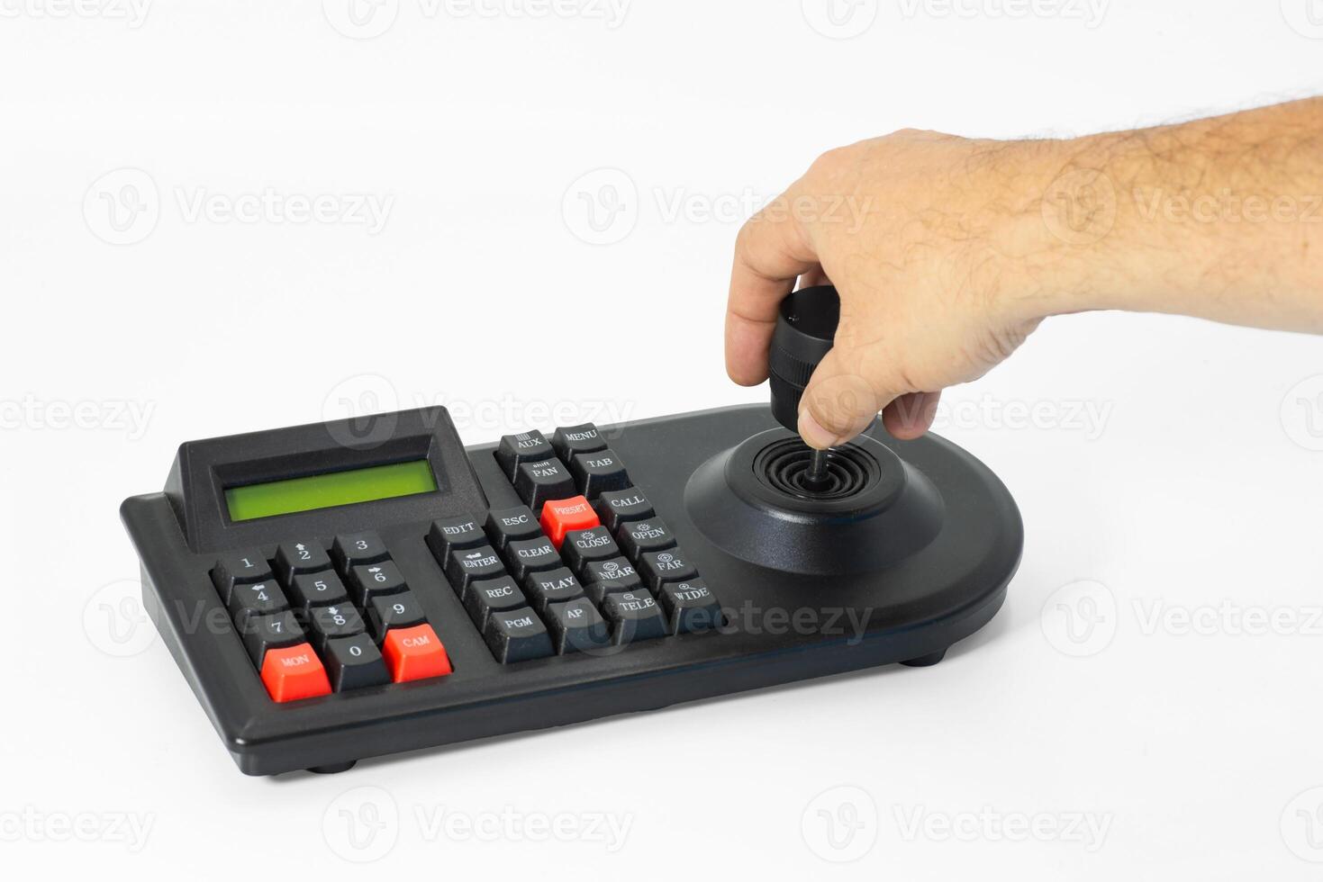 Hand using joystick on CCTV control panel for monitoring a secure environment photo