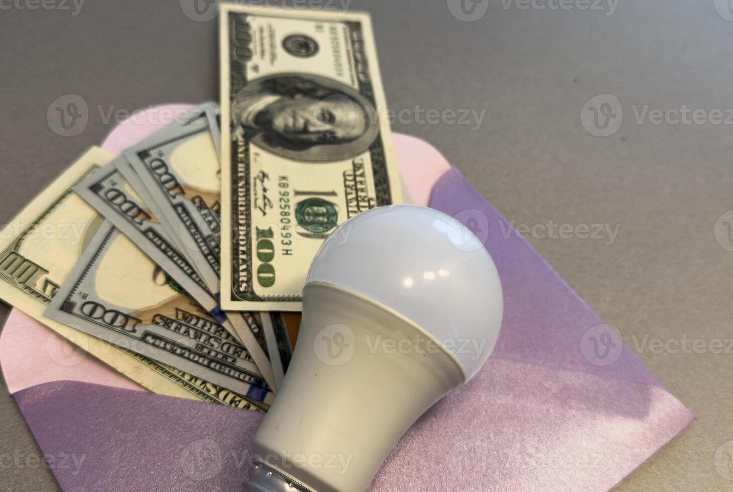 Energy saving light bulbs with american currency , dollars on a background. Payment for electricity, financial condition of the energy market, increase in energy prices. photo