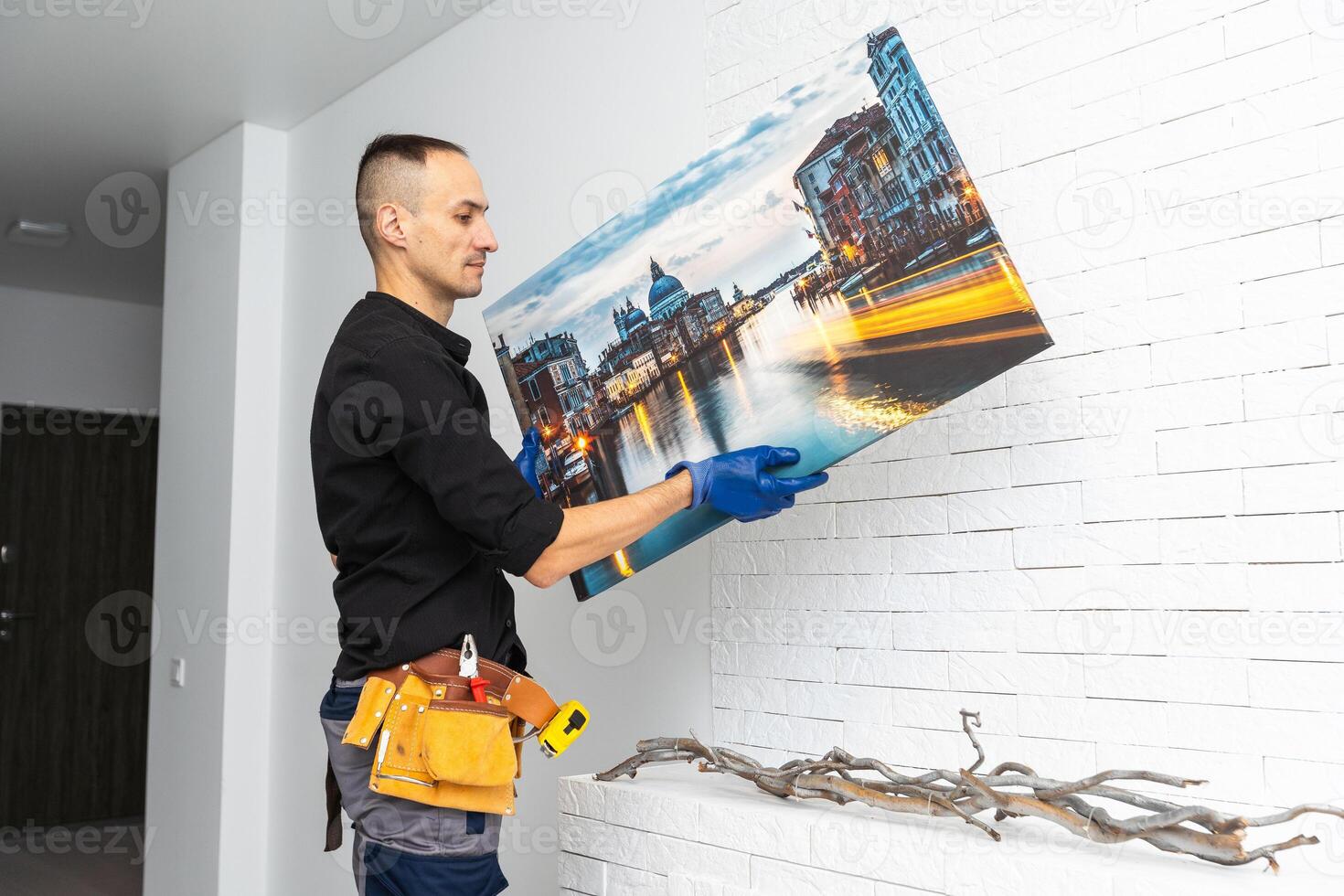 repairman master holds a photo canvas