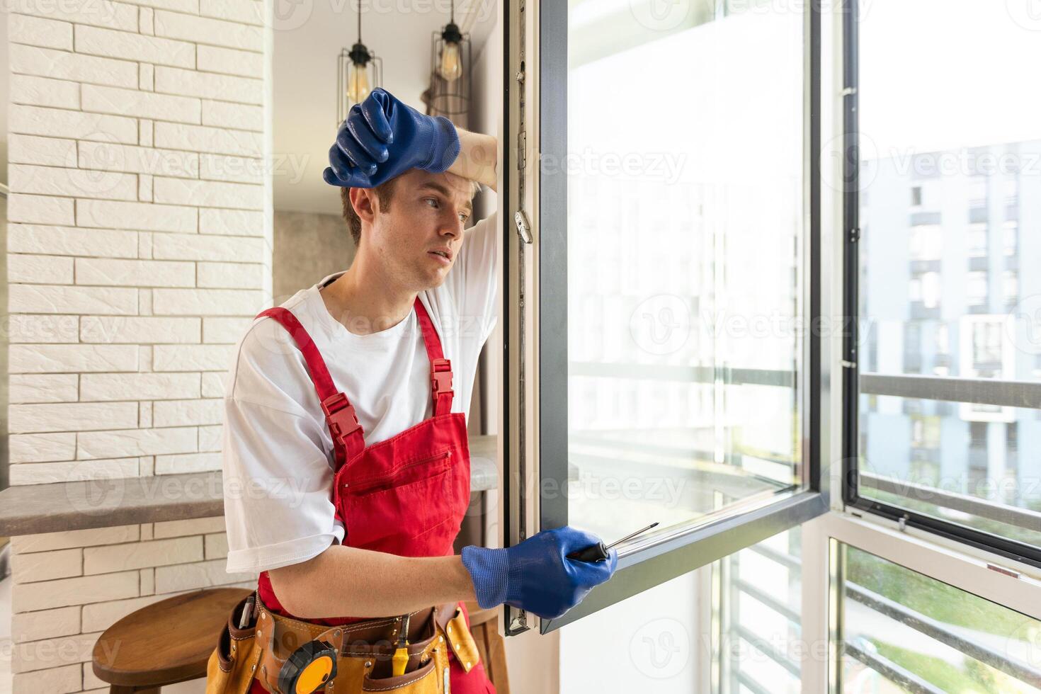 a repairman repairs, adjusts or installs metal-plastic windows in the apartment. glazing of balconies, loggias, verandas in house. production of double-glazed windows to individual sizes photo