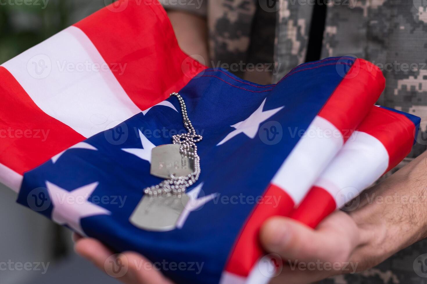 American soldier stands against white background with a flag. Concept of the day of remembrance of veterans. photo