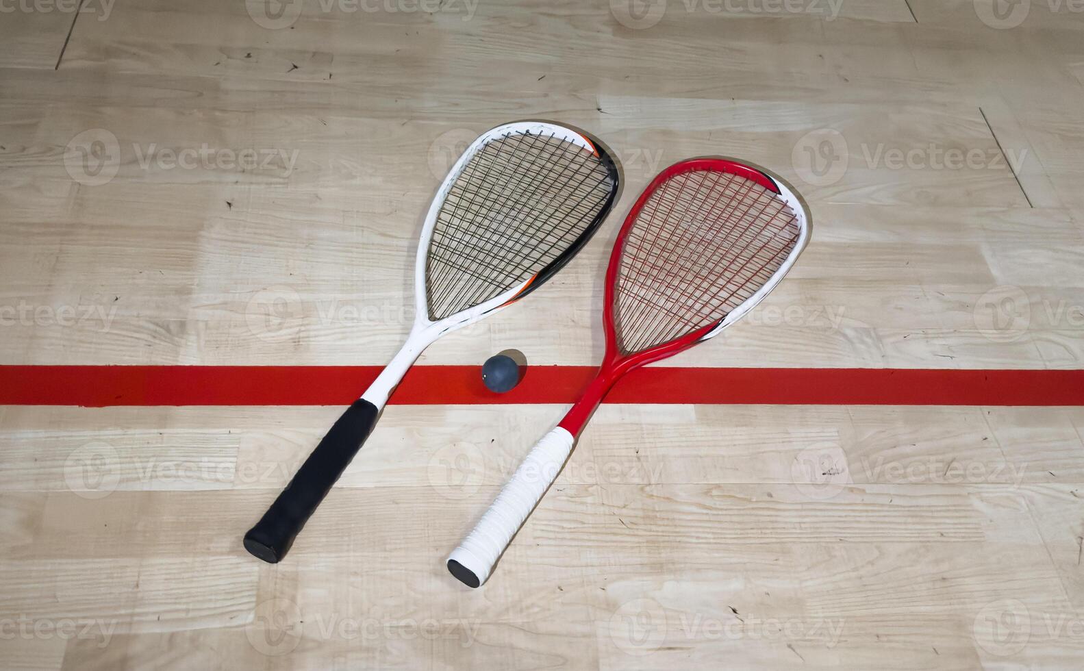 Squash rackets and ball on court floor, top view photo
