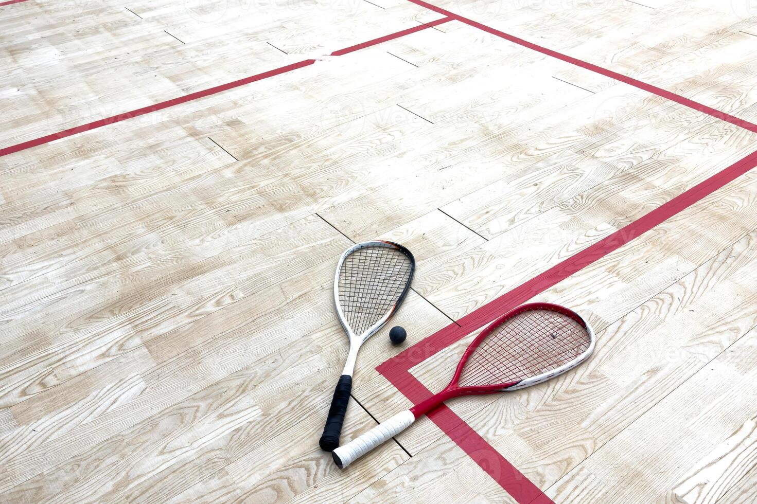Empty squash court and rackets on the wooden floor. photo