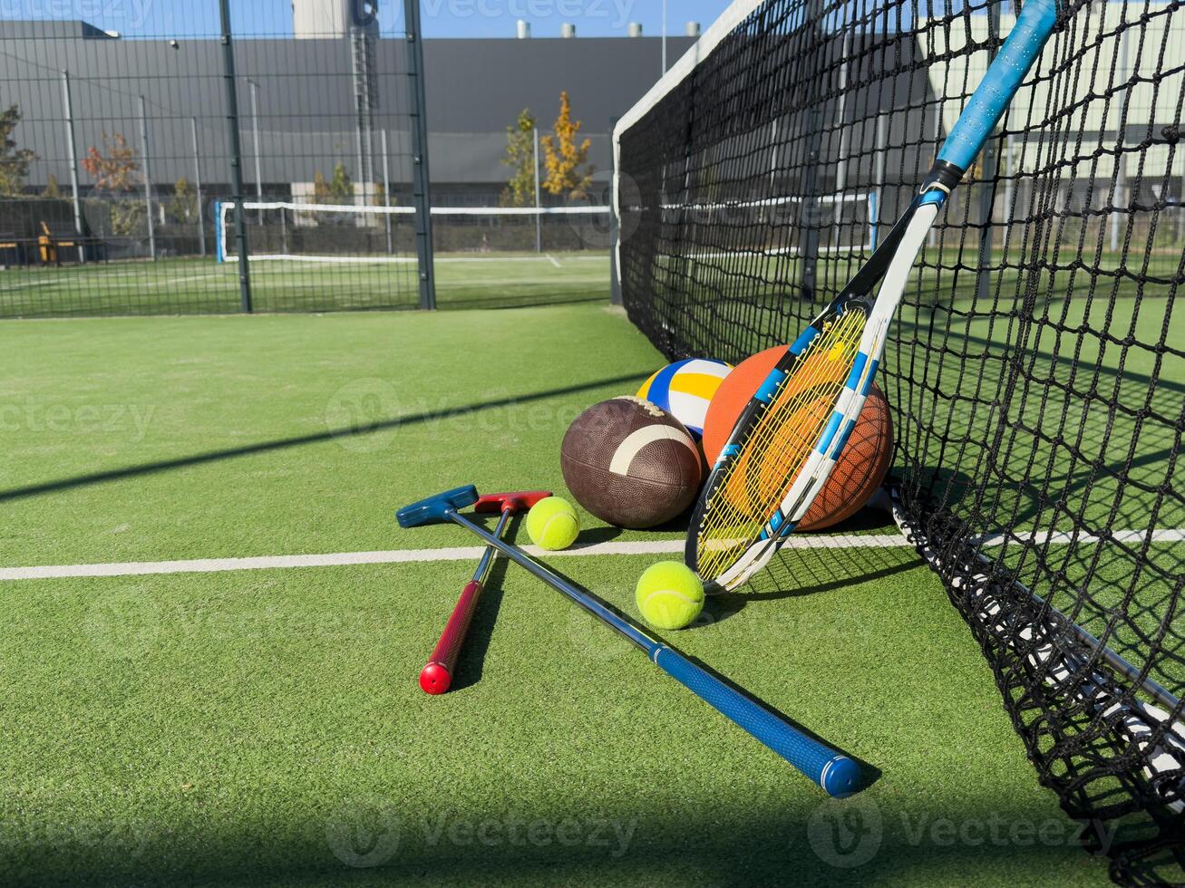 Different sports equipment on green grass, flat lay photo