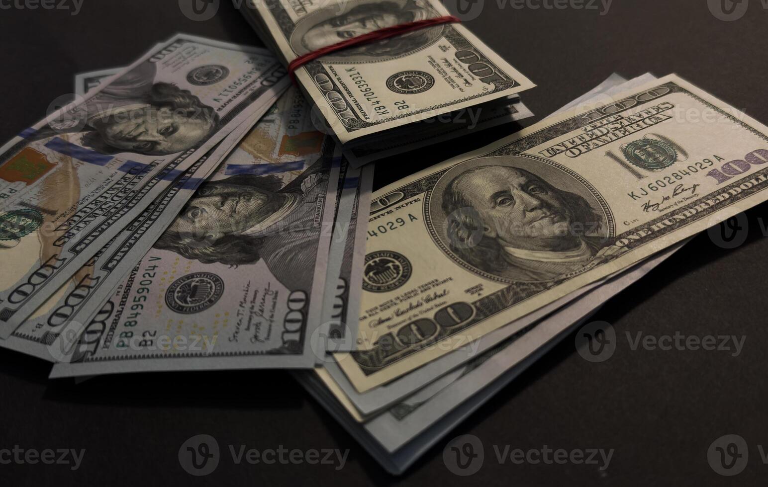 US Dollar bills bundles stack on black background. A pile of one hundred US banknotes with president portraits. Cash of hundred dollar bills, dollar background image with high resolution photo
