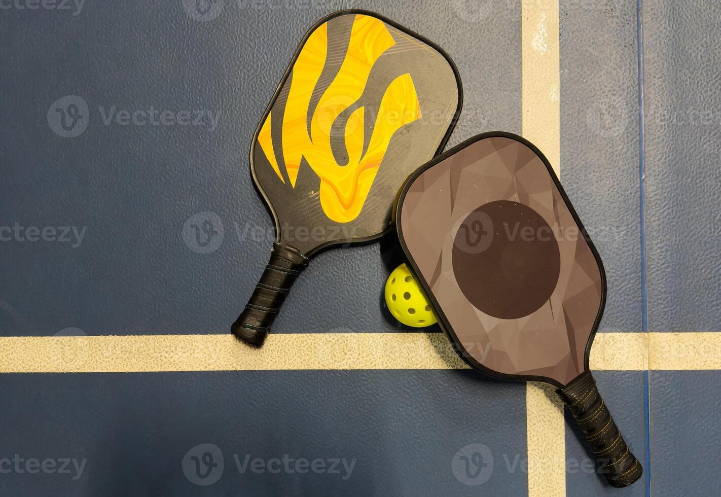 Pickleball tennis racket on the court. Blue background with copy space. Sport court and ball. photo