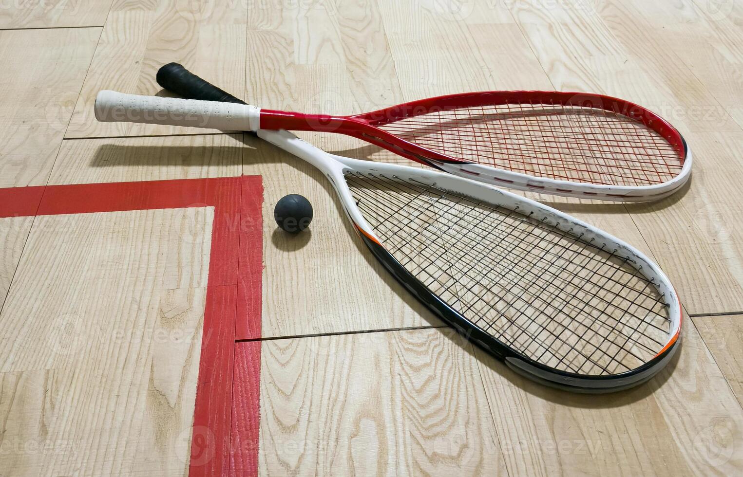 Empty squash court and rackets on the wooden floor. photo