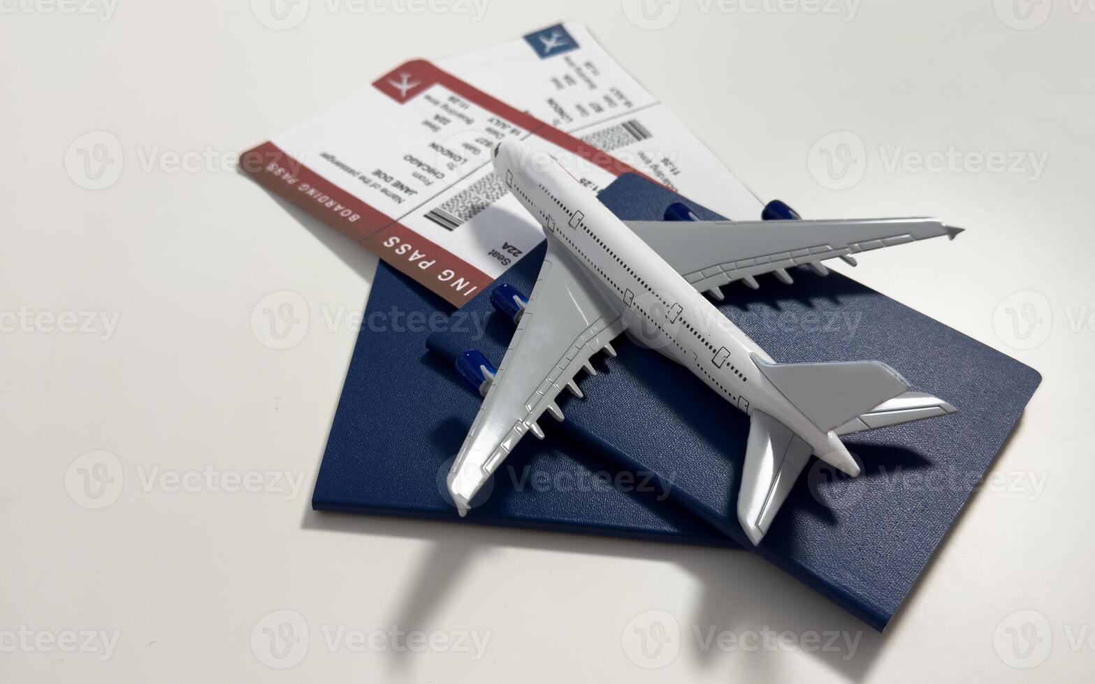Boarding pass, passport and toy aircraft on desk top view photo