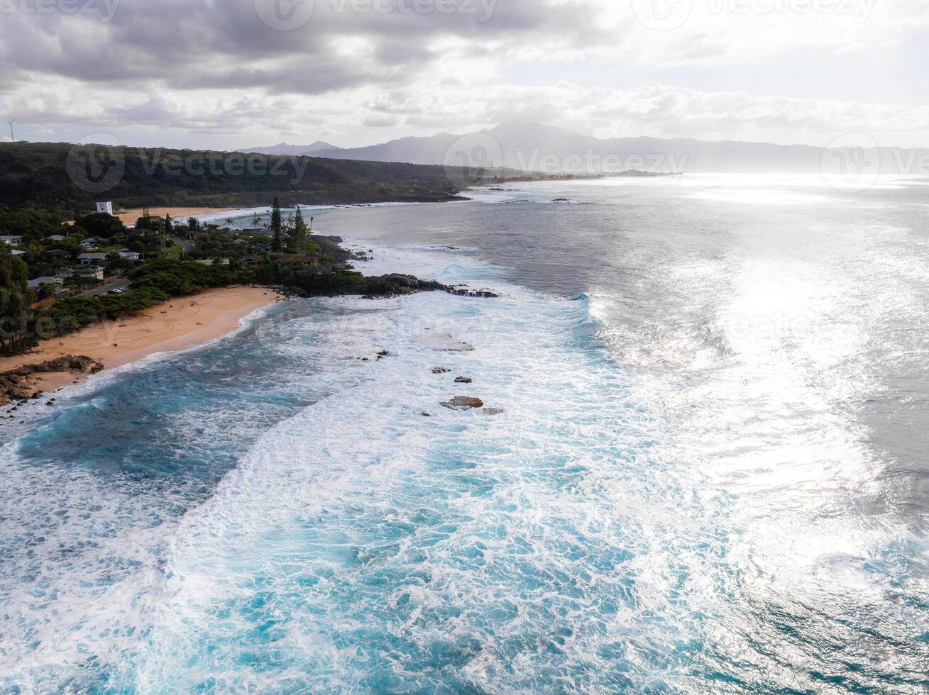 Aerial View of Oahu's North Shore Coastline with Waves and Hills photo
