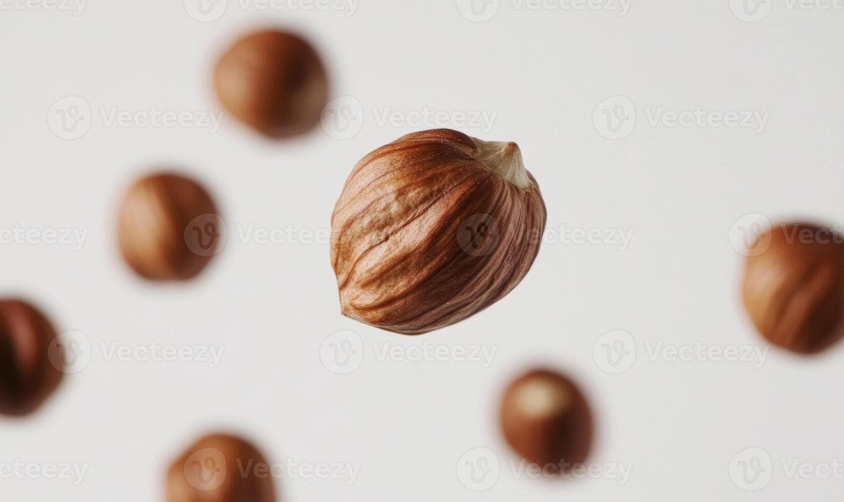 A nut is shown in the air with other nuts below it photo