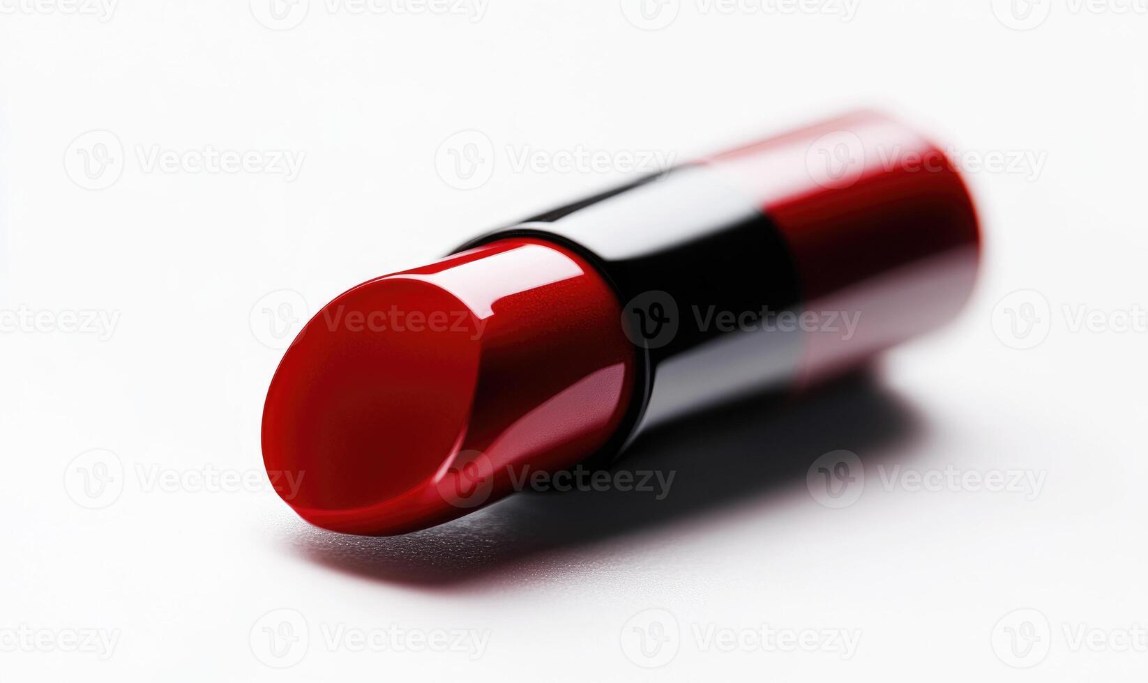 A red lipstick is laying on a white surface photo