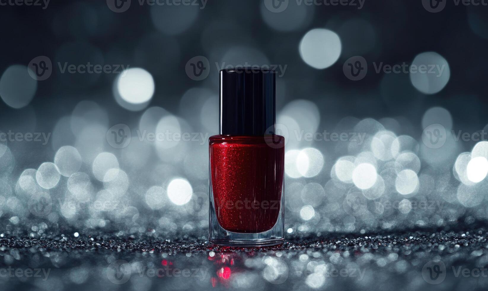 A bottle of red nail polish is sitting on a shiny surface photo