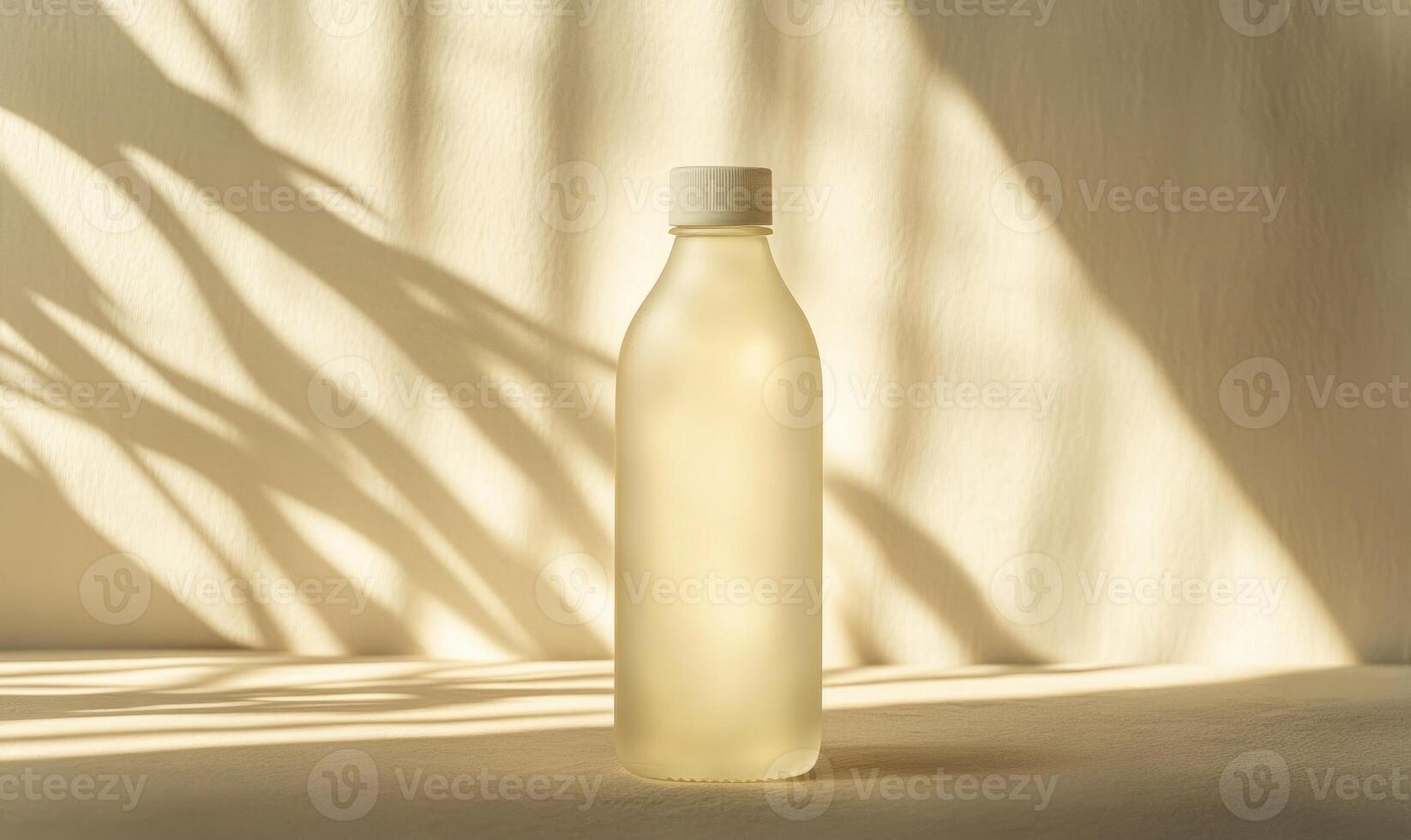 A clear bottle with a white cap sits on a table photo