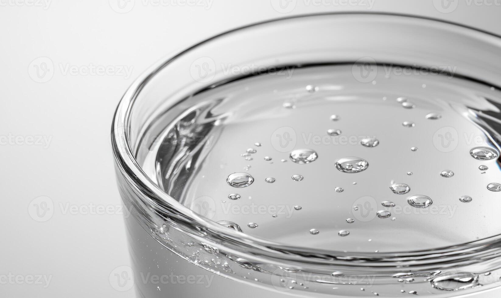 A glass of water with many small bubbles on the surface photo