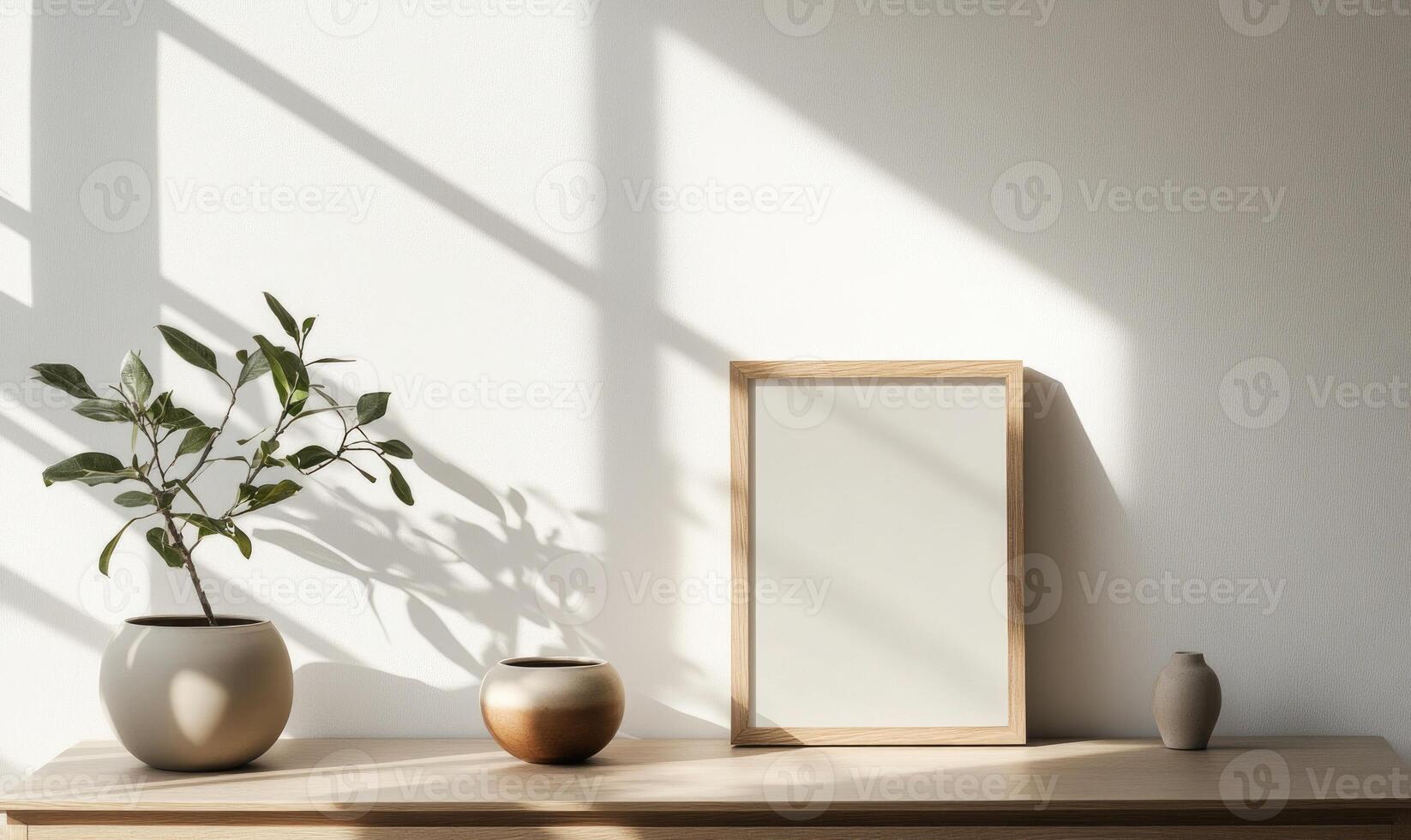 A white framed picture sits on a wooden shelf next to a vase and a potted plant photo