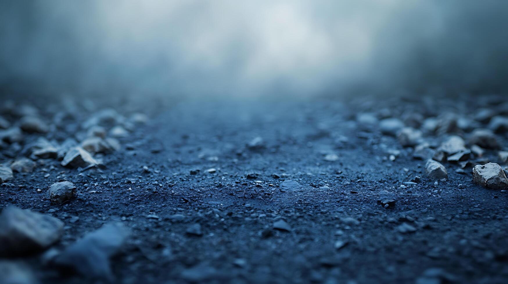 Dark rocky ground stretching into a misty atmosphere. The terrain appears bleak and somewhat desolate, under a hazy light. photo