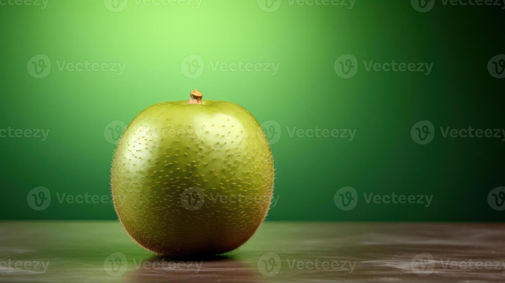 A green apple is placed on a table against a green background. photo