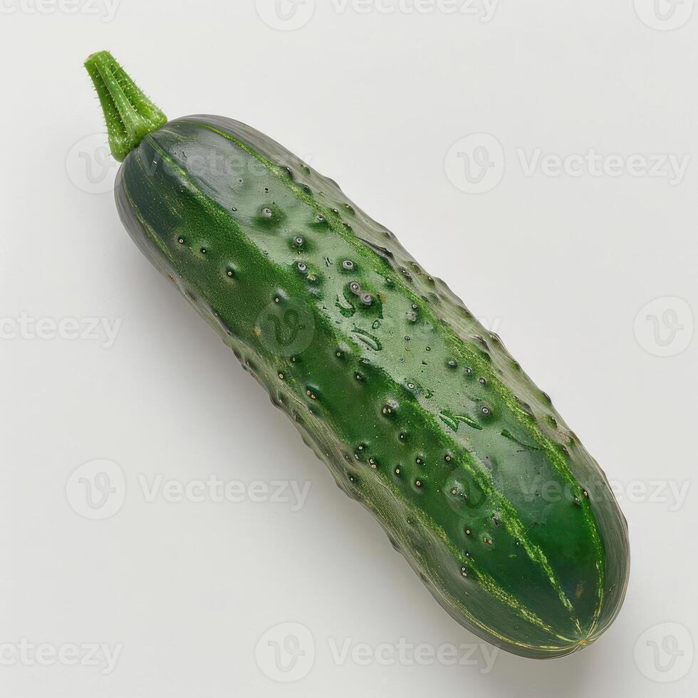 A cucumber with a green skin and a small leafy top photo