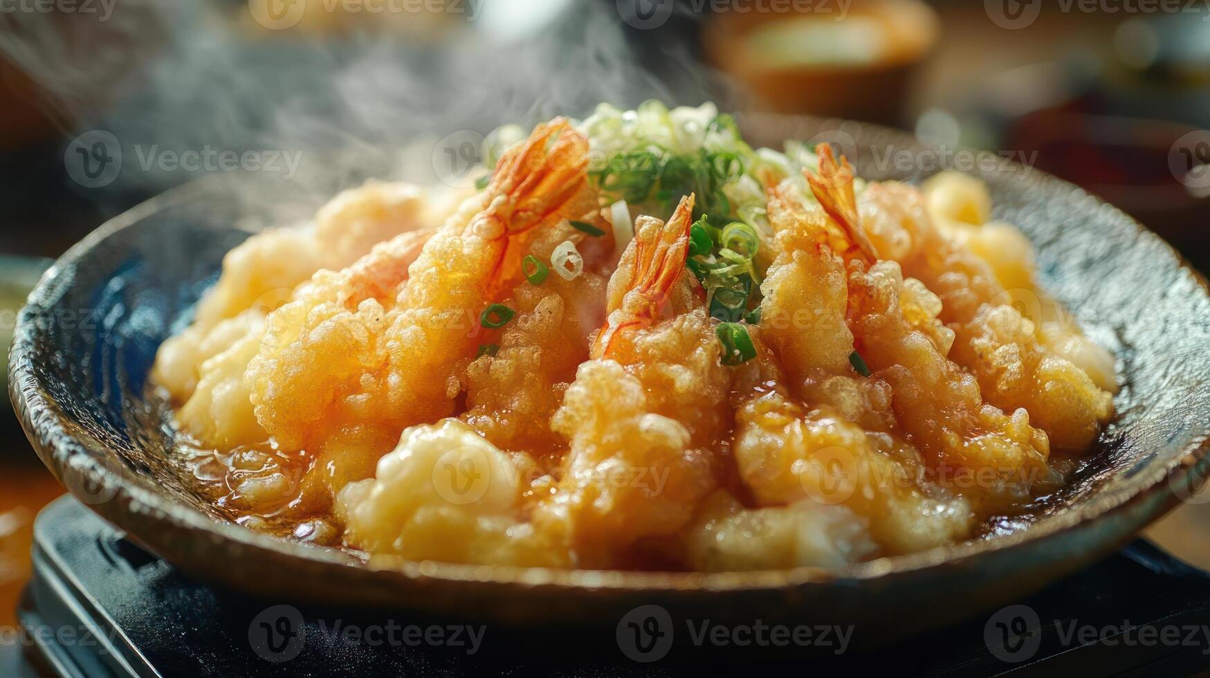 A bowl of shrimp tempura with sauce and green onions photo