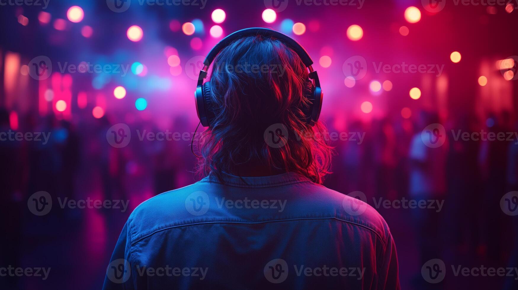 A person wearing headphones in front of a crowd photo