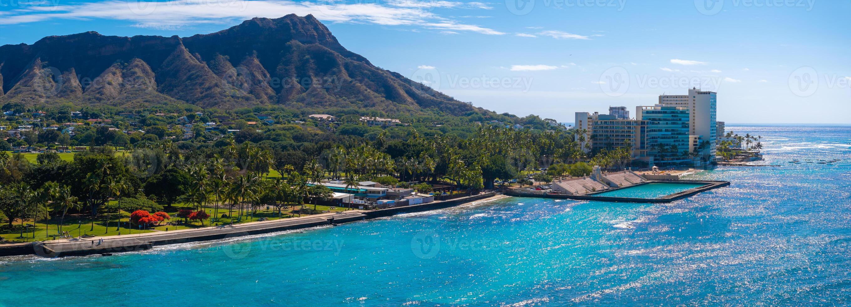 Aerial view of Waikiki Beach in Honolulu, Oahu, Hawaii, featuring Diamond Head Crater, turquoise waters, palm trees, and modern oceanfront buildings. photo
