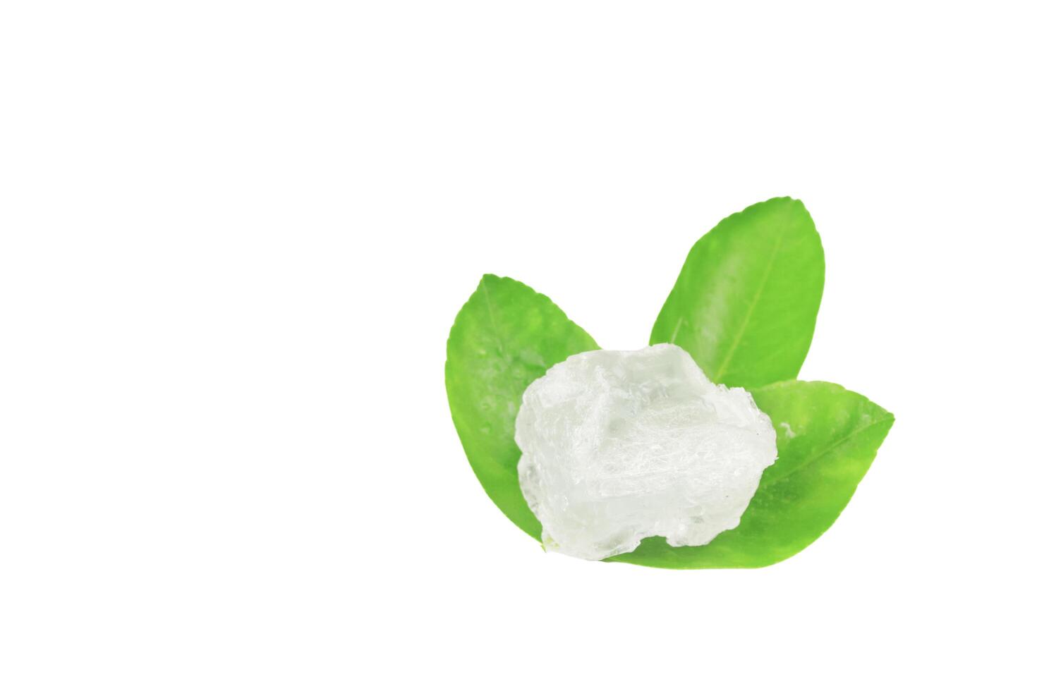 11. Pieces of alum stone on green leaf on white background. This image emphasizes the connection between natural minerals and plant based ingredients in traditional practices and holistic wellness. photo