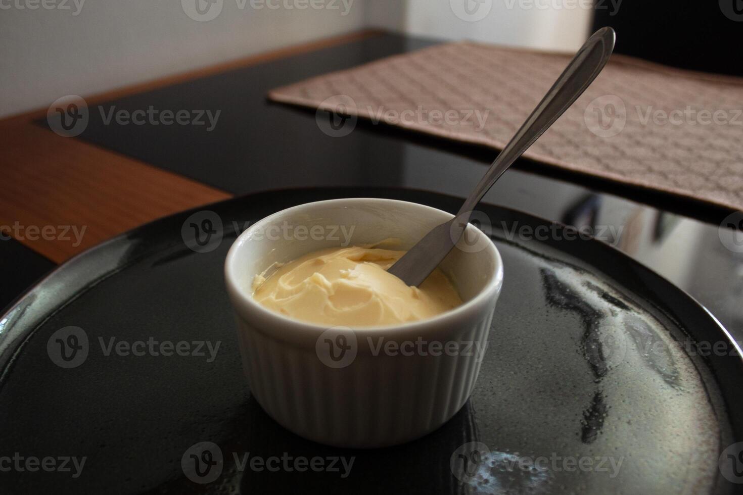Fresh butter in a white container with a metal spatula photo