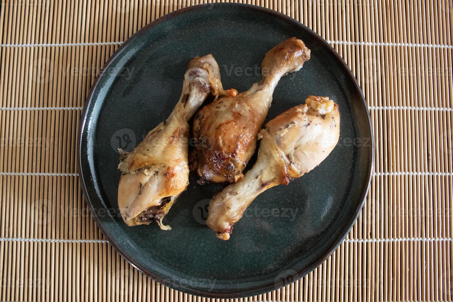Top view of three roasted chicken thighs on a plate photo