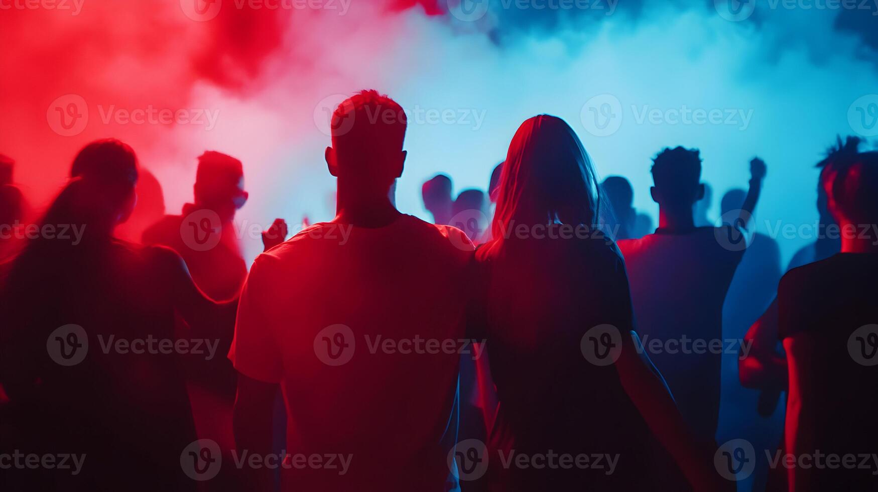 Captivating crowd immersed in vibrant red and blue lighting at an electrifying concert event photo