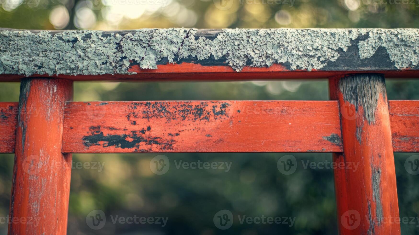 Traditional torii gate element with moss, textured red wooden posts, blurry bokeh backdrop photo