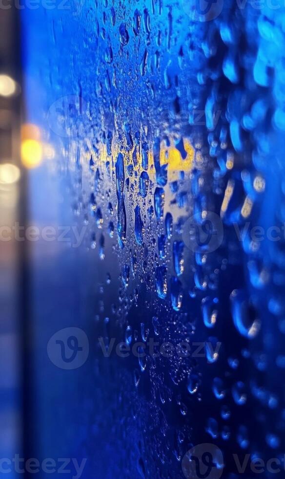 Evocative close up shot of raindrops clinging to glass surface with soft bokeh background photo