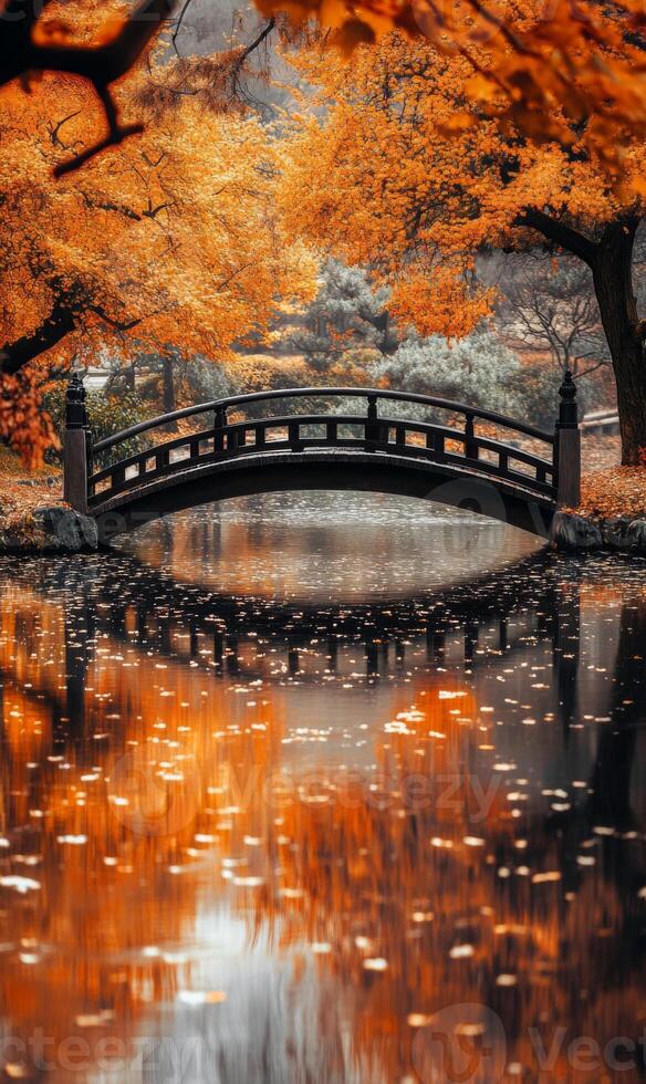 Serene autumnal landscape featuring a traditional bridge reflected in tranquil water photo