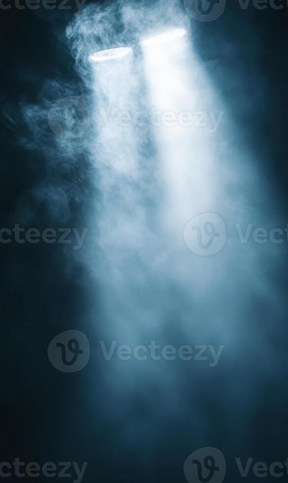 Mystical spotlights cutting through hazy atmosphere in a darkened space filling with fog photo